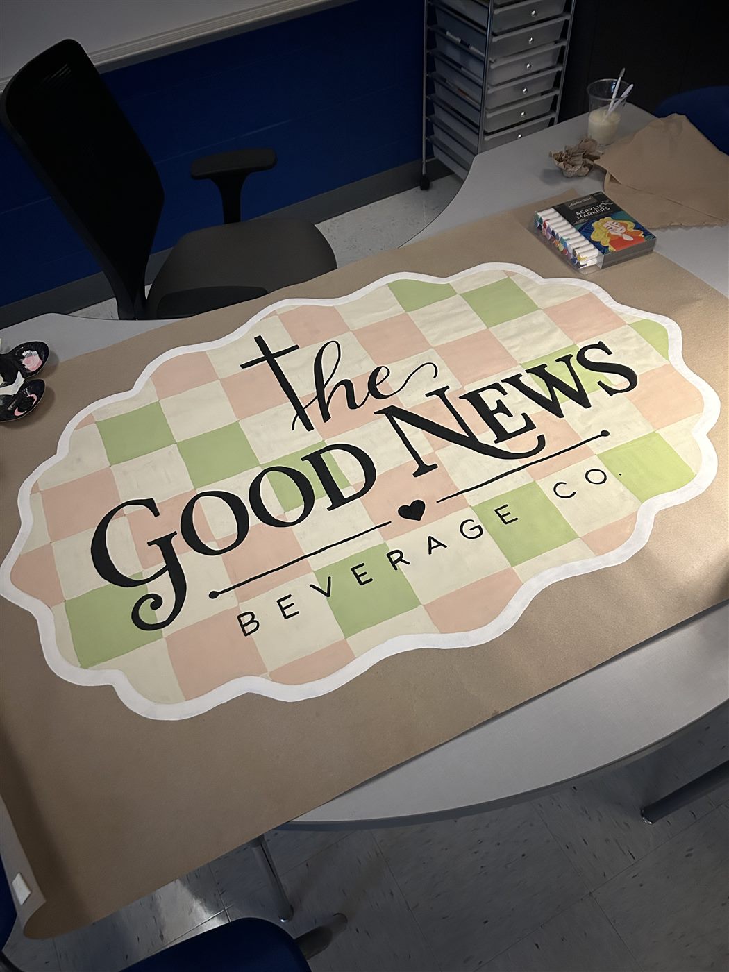 The Good News Beverage Co. hand-painted checkered banner